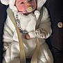 Nino participe au concours pour gagner de l'argent avec cette photo : baby, infant, car_seat, pacifier, white_clothing, onesie, hood, ears, cute, child, face, beads, accessory, seatbelt, soft_texture, warm, indoor, portrait, small_hand, cozy