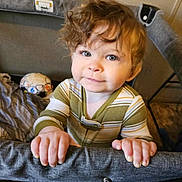 Arrow joined the competition — help win amazing prizes! toddler, child, curly_hair, playpen, striped_clothing, indoor, baby, hands, face, bright_eyes, soft_toy, ball, bed, blanket, looking_up, portrait, cute, young_child, home, curious