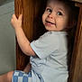 Arrow is registered to the contest to win money with this photo: toddler, child, smiling, wooden_table, indoor, playful, light_blue_shirt, checkered_shorts, floor, cute, face, sitting, peek, furniture, happy, young_child, wood, candid, portrait, curious