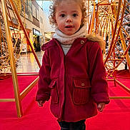 Kalia participe au concours pour gagner de l'argent avec cette photo : bright_colors, child, curly_hair, cute, festive_lights, golden_structures, holiday_decorations, indoor, jeans, person, playful, portrait, red_carpet, red_coat, shopping_mall, standing, toddler, white_scarf, white_shoes, winter_clothing