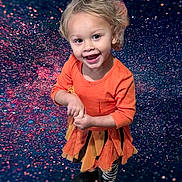 Marie is registered to the contest to win money with this photo: child, toddler, smiling, blonde_hair, orange_dress, zebra_leggings, black_boots, standing, happy, portrait, studio_background, glitter, sparkle, cosmic, colorful, playful_clothing, cute, fashion, fun, joyful