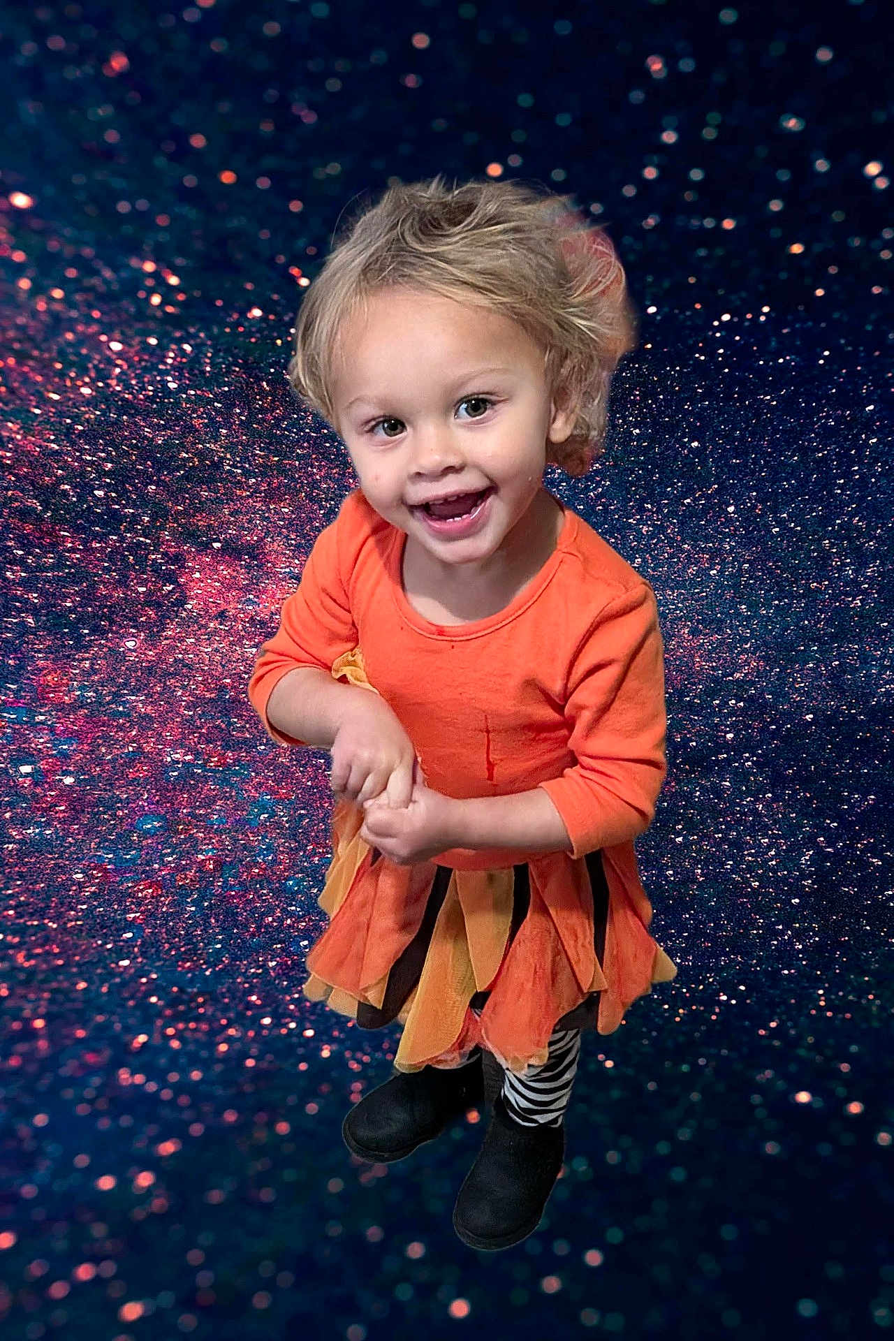 Marie is registered to the contest to win money with this photo: child, toddler, smiling, blonde_hair, orange_dress, zebra_leggings, black_boots, standing, happy, portrait, studio_background, glitter, sparkle, cosmic, colorful, playful_clothing, cute, fashion, fun, joyful