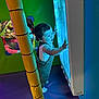 blue_light, child, colorful, curious, exploring, face, fun, happy, indoor_play_area, interactive, overalls, padded_floor, person, play, socks, soft, standing, toddler, yellow_pole, young_child
