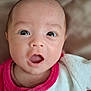 adorable, baby, blanket, close_up, drool, eyes, face, gaze, head, indoor, infant, mouth_open, newborn, onesie, person, pink_clothing, portrait, skin, soft_texture, surprised_expression