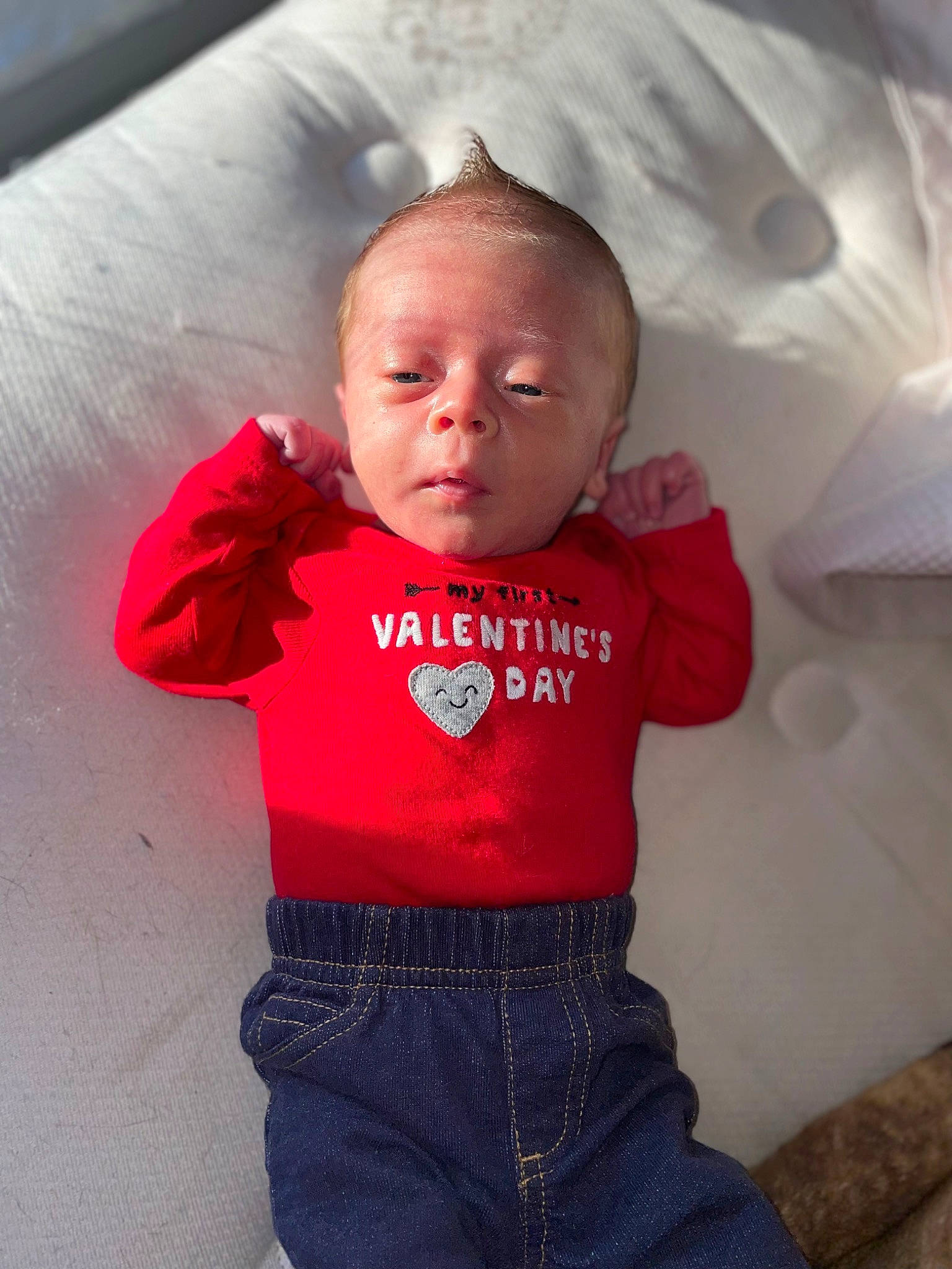 David is registered to the contest to win money with this photo: baby, baby_toddler_clothing, cheek, comfort, electric_blue, eye, happy, lip, magenta, neck, nose, pattern, person, pink, red, sitting, sleeve, t_shirt, textile, toddler