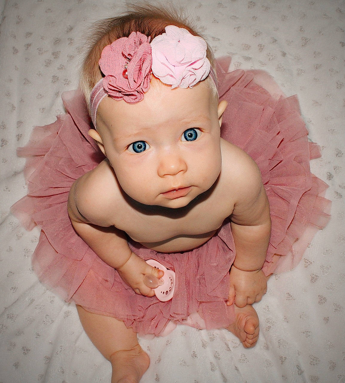 Emilie participe au concours pour gagner de l'argent avec cette photo : baby, baby_toddler_clothing, cheek, child, costume_accessory, fashion_accessory, flower, hair_accessory, head, headband, headpiece, headwear, jewellery, magenta, peach, person, petal, pink, skin, textile