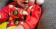 Major is registered to the contest to win money with this photo: baby, child, infant, portrait, smiling, happy, santa_hat, christmas, festive, red_clothing, green_blanket, chair, indoor, seated, face, eyes, mouth, photograph, cozy, holiday