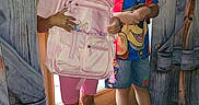 Nevaeh is registered to the contest to win money with this photo: backpack, boy, children, clothing, doorway, family, girl, indoors, pink_backpack, playful, portrait, school, school_day, shoes, siblings, smiling, standing, superhero, window, wooden_door