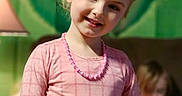 Nevaeh is registered to the contest to win money with this photo: child, girl, portrait, smiling, pink_dress, hair_bow, necklace, blonde_hair, standing, indoors, colorful_background, toy, furniture, soft_lighting, closeup, fashion, happy, facial_expression, family_scene, photograph