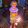 Nevaeh joined the competition — help win amazing prizes! child, girl, birthday, sparkler, smiling, outdoor, deck, wooden_floor, party, celebration, dress, shirt, shorts, shoes, stroller, patio, furniture, portrait, standing, fireworks