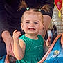 Constance a rejoint le concours — aidez-le/la à gagner de superbes lots ! child, toddler, pigtails, hair_ties, green_dress, smile, closeup, portrait, amusement_ride, ride_seat, adult_hands, support, outdoor, happy, cute, eyes, teeth, playground, colorful, candid