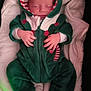 baby, sleeping, onesie, hood, blanket, infant, cozy, red_buttons, candy_cane, green_clothing, white_blanket, soft_fabric, newborn, hands, peaceful, cute, portrait, indoors, child, warm