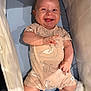 Louis is registered to the contest to win money with this photo: baby, infant, smiling, onesie, striped_socks, crib, blue_mattress, cute, happy, child, clothing, hand, footwear, person, lying_down, indoor, skin, face, expression, baby_garment
