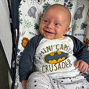 Louis joined the competition — help win amazing prizes! baby, smiling, batman, shirt, clothing, baby_seat, pattern, elephant, flower, happy, infant, cute, child, indoor, person, sitting, comfortable, playful, young, portrait