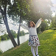 élae a rejoint le concours — aidez-le/la à gagner de superbes lots ! child, girl, outdoor, river, trees, grass, sunlight, white_tights, black_shoes, floral_skirt, long_sleeve, purse, nature, greenery, smiling, happy, pose, daylight, park, scenic