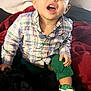 Kingstyn joined the competition — help win amazing prizes! toddler, child, plaid_shirt, green_pants, sneakers, bed, blanket, indoor, smiling, happy, person, young_child, casual_clothing, footwear, furniture, portrait, cute, expression, cozy, home