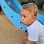 Milann participe au concours pour gagner de l'argent avec cette photo : child, toddler, blond_hair, white_shirt, crawling, playground, slide, blue_slide, outdoor, sand, curious, young_child, hands, face, close_up, daylight, playing, park, fun, baby