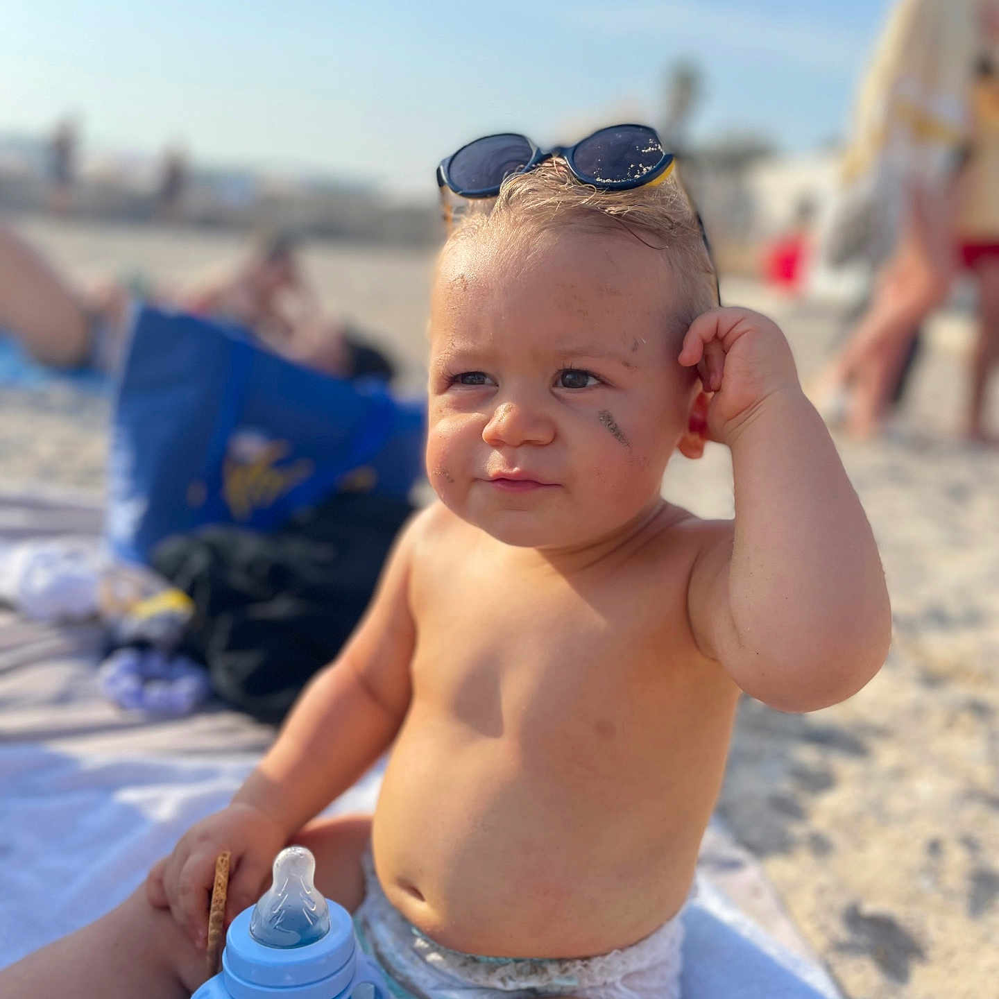 Milann participe au concours pour gagner de l'argent avec cette photo : baby, beach, biscuit, child, diaper, expression, face, hand, outdoor, person, portrait, sand, sippy_cup, skin, summer, sunglasses, sunlight, toddler, towel, vacation