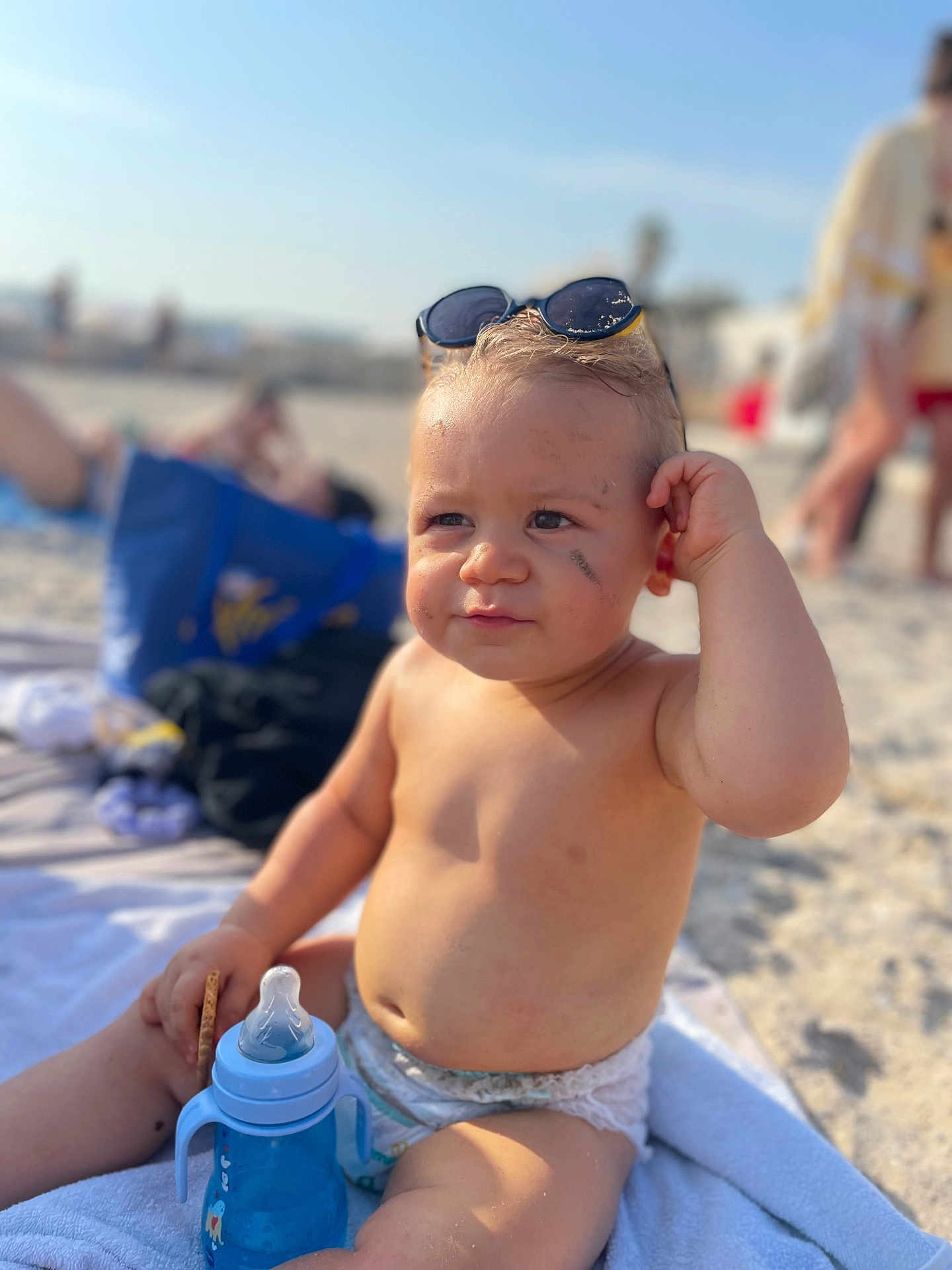 Milann participe au concours pour gagner de l'argent avec cette photo : toddler, baby, child, beach, sunglasses, sippy_cup, biscuit, diaper, sand, towel, sunlight, outdoor, summer, skin, hand, face, expression, person, portrait, vacation