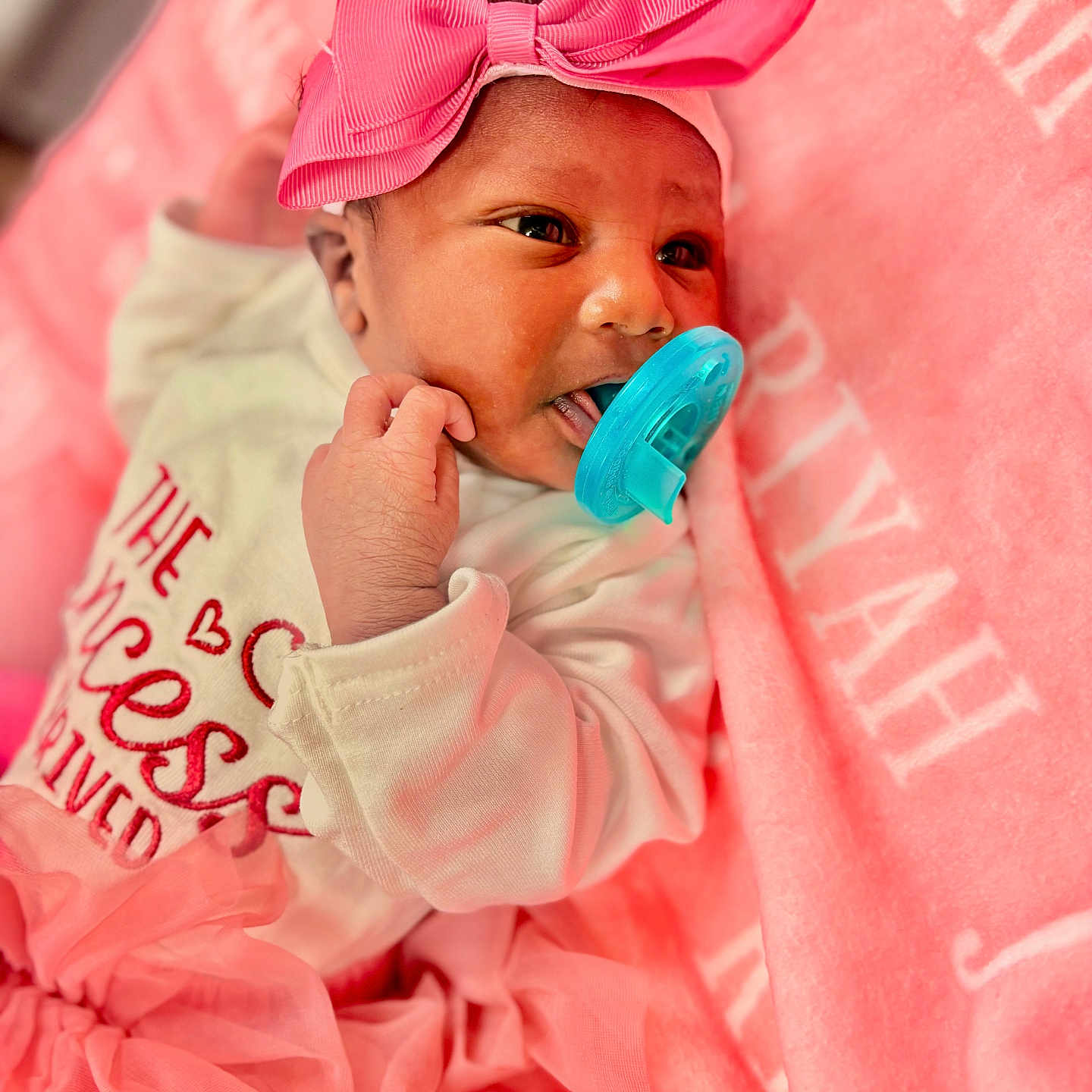 Jriyah is registered to the contest to win money with this photo: baby, infant, pacifier, pink_bow, pink_blanket, pink_tutu, white_onesie, newborn, cute, portrait, child, face, hand, soft_texture, fabric, resting, laying_down, indoor, closeup, adorable