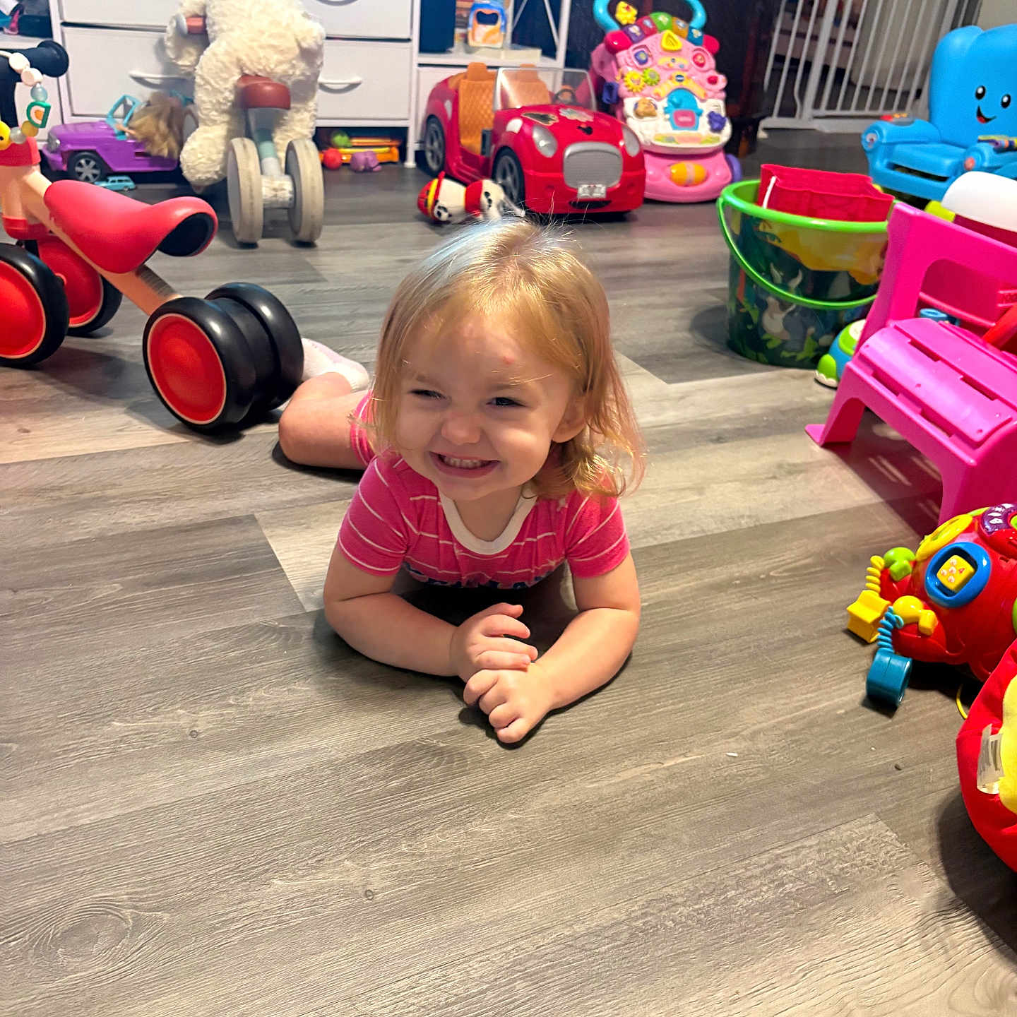 Barbie Rae joined the competition — help win amazing prizes! child, toddler, smiling, portrait, indoors, playroom, toys, toy_cars, stuffed_animal, ride_on_toy, tricycle, pink_shirt, sitting, floor, wood_floor, playpen, toy_chair, colorful, happy, 家庭