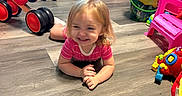 Barbie Rae is registered to the contest to win money with this photo: toddler, child, smiling, happy, portrait, playroom, toys, toy_cars, tricycle, ride_on_toy, stuffed_animal, plush_sheep, toy_phone, toy_chair, buckets, indoor, floor, sitting, blonde_hair, colorful