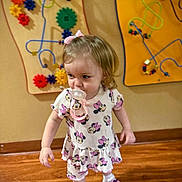 Barbie Rae joined the competition — help win amazing prizes! blonde_hair, bow, child, colorful, cute, dress, gears, indoor, minnie_mouse, pacifier, person, playroom, shoes, socks, toddler, toys, walking, wall_toys, wooden_floor, young_child