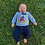 baby, child, grass, outdoor, smiling, happy, clothing, sweatshirt, pants, barefoot, greenery, nature, cute, infant, person, lying_down, casual_wear, daylight, playful, mickey_mouse