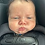 baby, infant, face, car_seat, harness, straps, pout, chubby_cheeks, black, closeup, child, person, seatbelt, safety, expression, cute, young, head, indoors, portrait