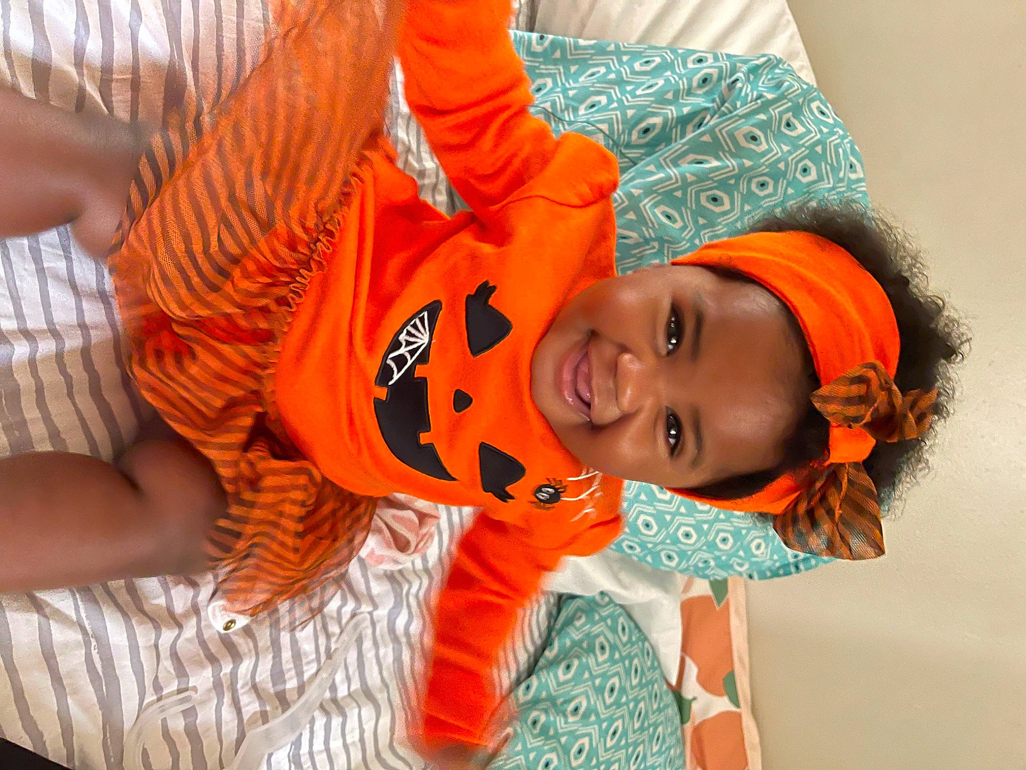 Aubrey joined the competition — help win amazing prizes! baby, child, costume, flooring, fun, happy, headwear, joy, leisure, mouth, orange, pattern, person, play, room, sitting, sleeve, smile, t_shirt, toddler