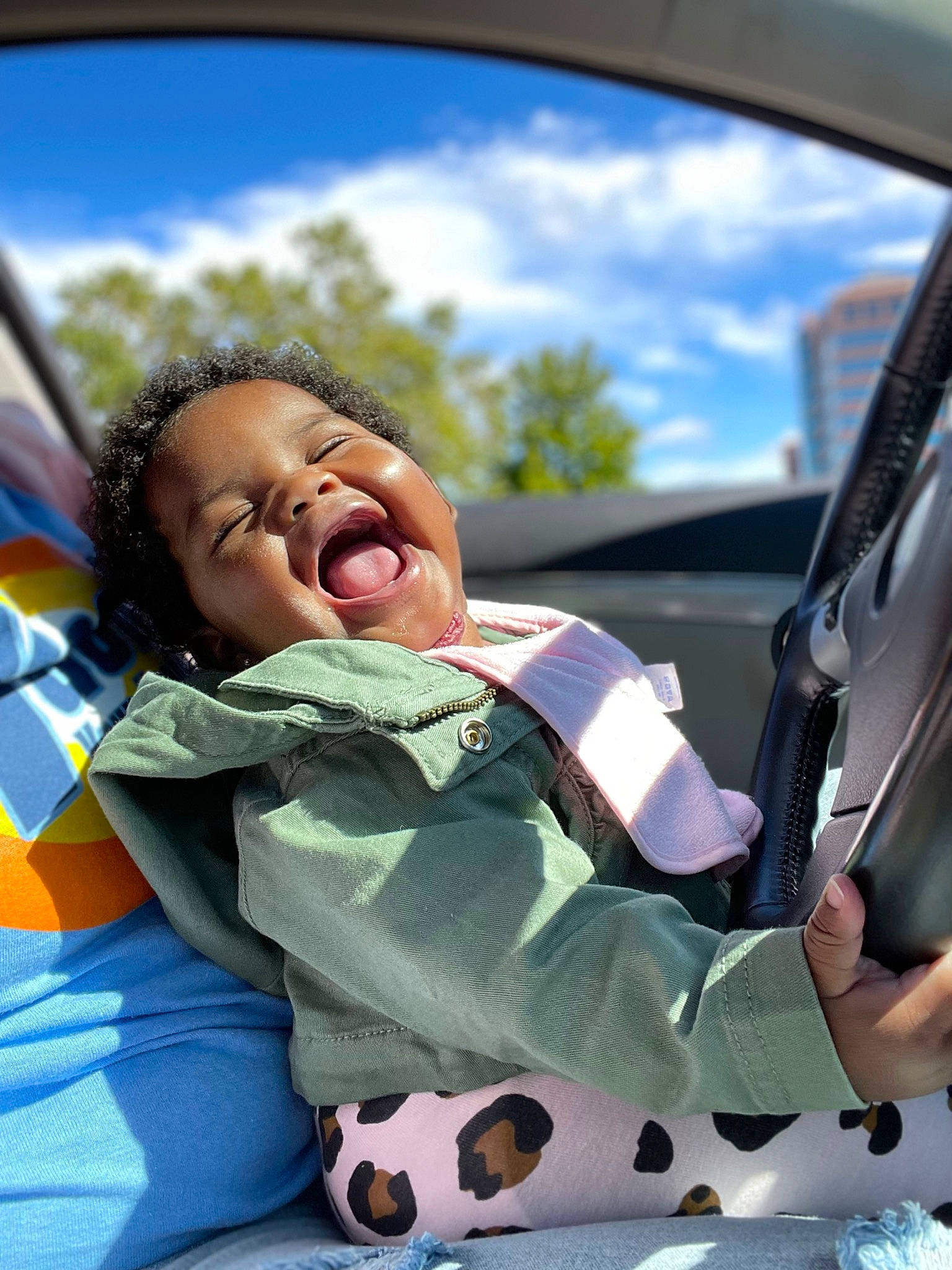 Aubrey joined the competition — help win amazing prizes! auto_part, automotive_exterior, automotive_mirror, baby, car, cloud, fun, grass, happy, leisure, motor_vehicle, person, plant, rear_view_mirror, recreation, sky, smile, steering_wheel, toddler, tree