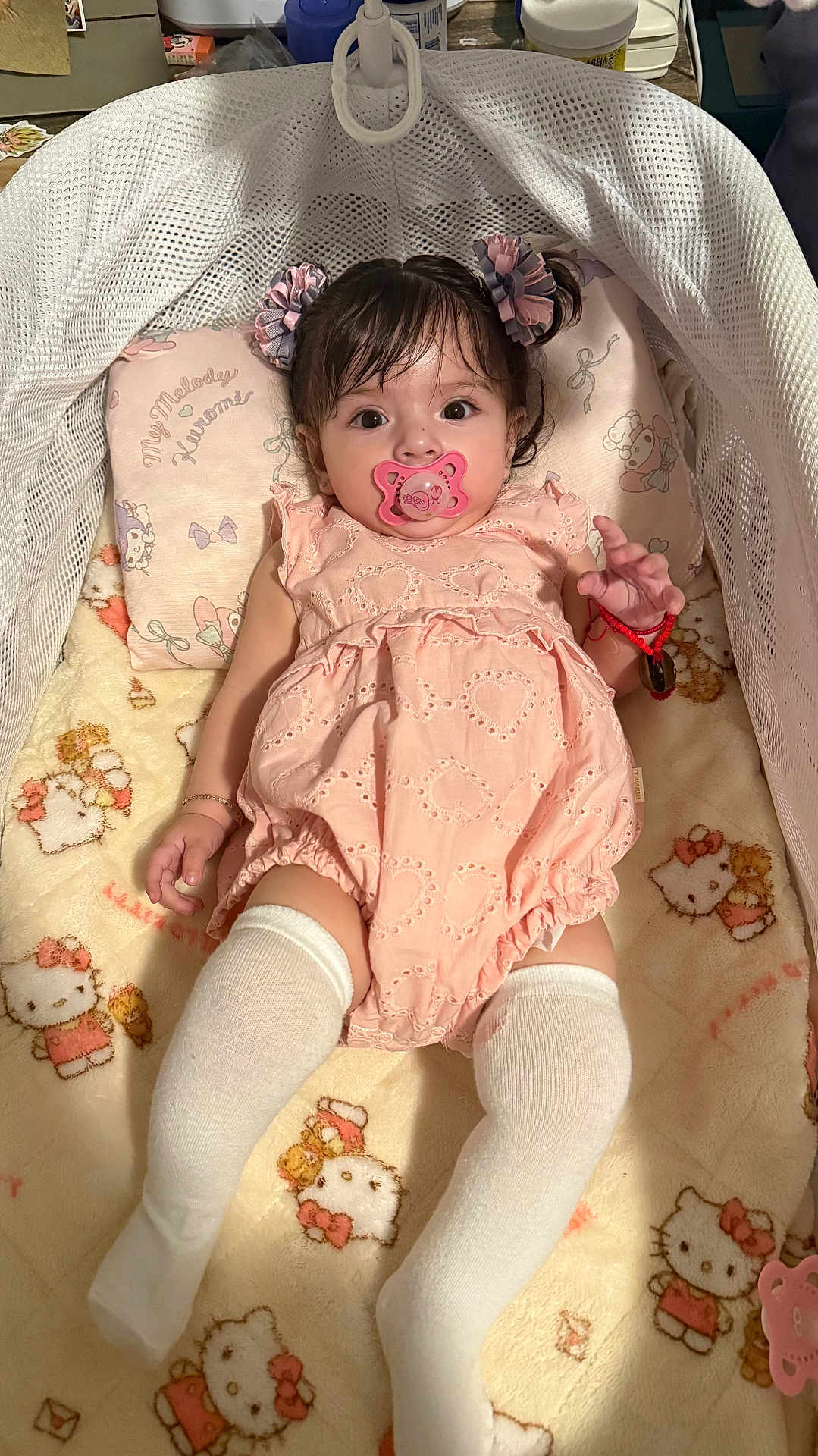 Camila joined the competition — help win amazing prizes! baby, infant, pacifier, pink_outfit, pigtails, white_socks, hello_kitty, blanket, baby_bed, cute, child, portrait, indoor, sleeping_area, toy, girl, soft_lighting, bracelet, pillow, comfort
