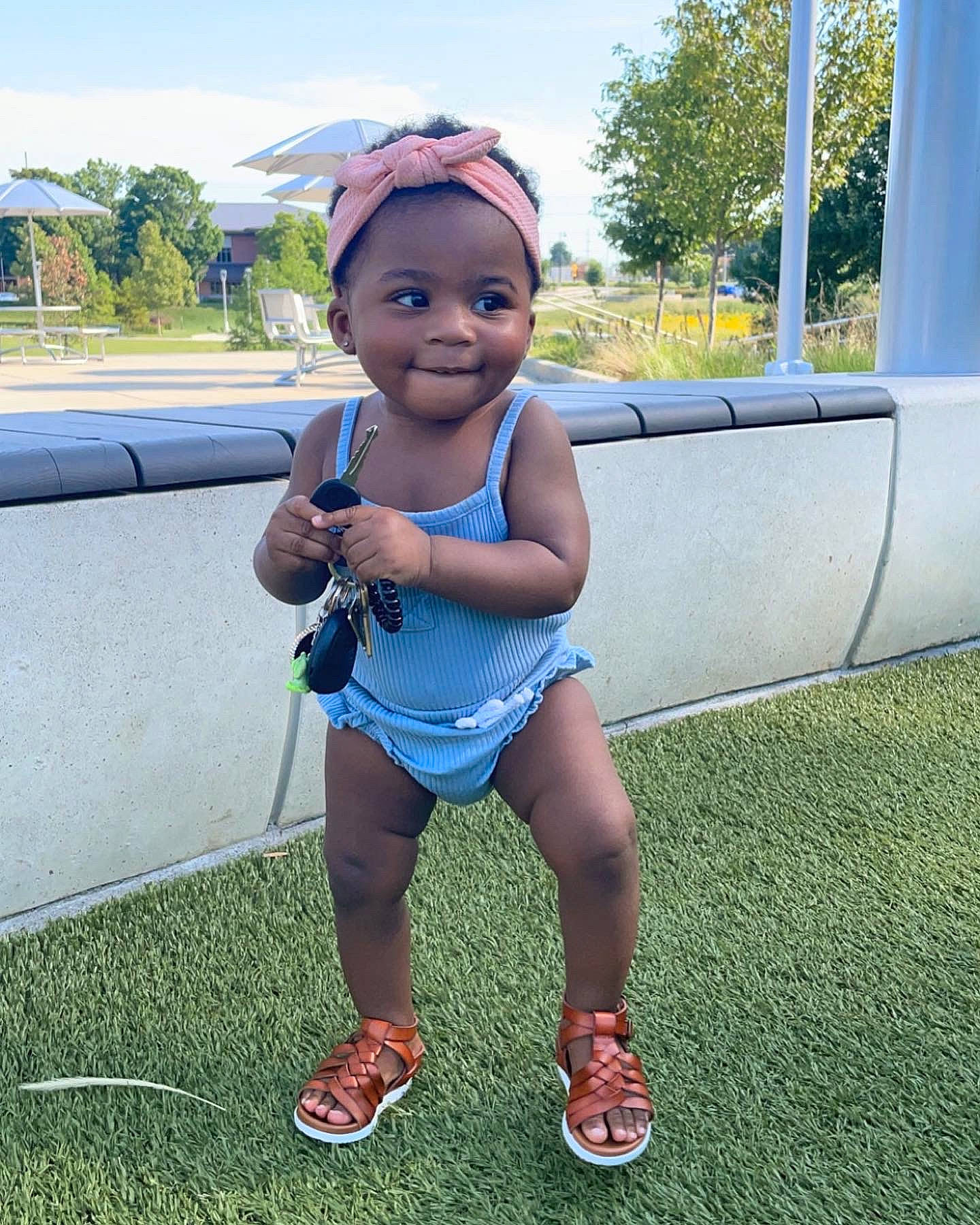 Lia is registered to the contest to win money with this photo: azure, cool, finger, fun, grass, happy, head, joy, knee, leg, leisure, person, recreation, shoe, shorts, sky, smile, summer, thigh, toddler