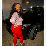 Paisley joined the competition — help win amazing prizes! woman, smiling, night, car, black_car, red_leggings, pink_sweater, boots, streetlight, outdoor, posing, long_hair, asphalt, vehicle, casual_clothing, side_view, urban, nighttime, person, portrait