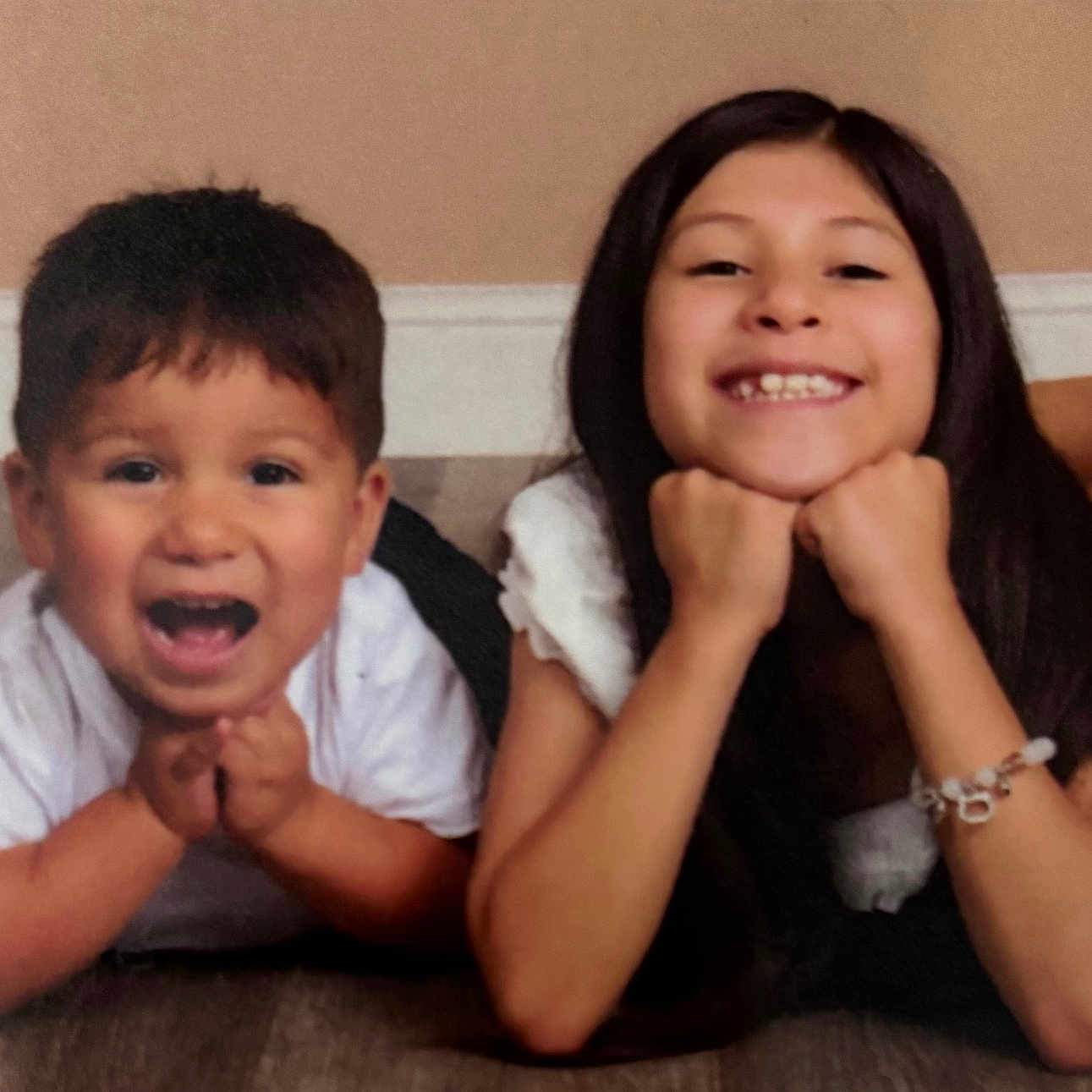 Isaiah Ramos is registered to the contest to win money with this photo: bracelet, casual, child, cute, face, floor, hands, happy, indoor, kids, long_hair, person, playful, portrait, shoe, short_hair, siblings, smiling, white_shirt, young