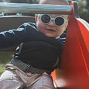 Nahël participe au concours pour gagner de l'argent avec cette photo : casual, child, cute, daylight, fashion, fun, happy, jacket, outdoor, pants, person, play, playground, recreation, slide, smile, sunglasses, sunlight, toddler, young