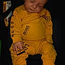 Maïlo participe au concours pour gagner de l'argent avec cette photo : baby, sleeping, yellow_clothing, car_seat, child, infant, sock, face, hand, footwear, dark_background, seatbelt, casual_wear, relaxed, indoors, portrait, young_child, cute, resting, small_hands