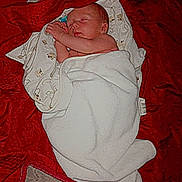 Maïlo participe au concours pour gagner de l'argent avec cette photo : baby, newborn, sleeping, blanket, red, white, bed, infant, peaceful, wrapped, soft, cute, child, resting, cozy, pattern, fabric, skin, portrait, indoor