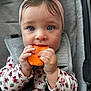 baby, child, carrot, headband, pink, blue_eyes, car_seat, seatbelt, floral_shirt, cute, hands, face, portrait, indoor, closeup, eating, infant, young_child, person, safety