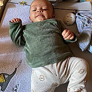 Aaron participe au concours pour gagner de l'argent avec cette photo : baby, infant, child, lying_down, green_clothing, hedgehog_pattern, elephant_mat, baby_care, soft_toys, pillow, blanket, face, hands, feet, indoor, cute, cozy, expression, person, nursery