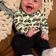 Braxton is registered to the contest to win money with this photo: baby, smiling, sitting, couch, blanket, knit, clothing, white_socks, happy, infant, face, portrait, home, indoors, cute, child, person, cozy, fabric, furniture