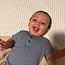 Alejandro is registered to the contest to win money with this photo: baby, child, smiling, striped_onesie, blanket, lying_down, happy, cute, infant, face, portrait, indoors, skin, head, hand, toddler, expression, young, childhood, person