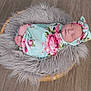 baby, newborn, wrapped, blanket, headband, floral, basket, fur_rug, floor, wooden_floor, sleeping, peaceful, cute, infant, portrait, indoors, soft_texture, resting, cozy, child