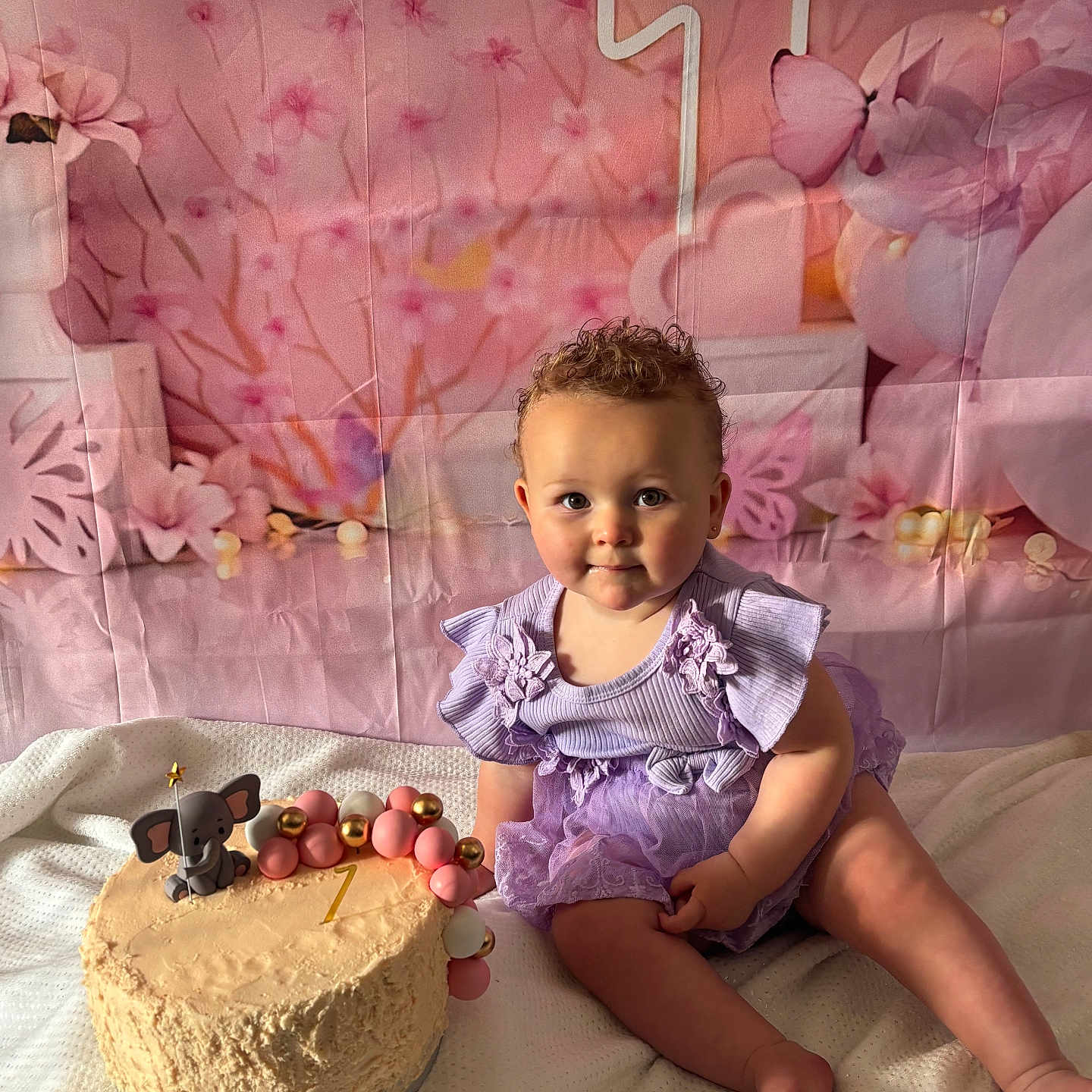 Grace joined the competition — help win amazing prizes! baby, balloons, birthday_cake, butterfly, cake_topper, celebration, child, cute, decorations, elephant_toy, first_birthday, flower_backdrop, happy, indoors, pink_decor, portrait, purple_dress, sitting, smiling, soft_lighting