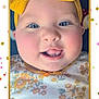 baby, child, face, headband, yellow_bow, blue_eyes, smile, tongue, teeth, floral_clothing, cheeks, closeup, portrait, cute, infant, pink_cheeks, confetti, frame, happy, indoors