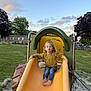 Giulia a rejoint le concours — aidez-le/la à gagner de superbes lots ! child, slide, playground, yellow_slide, barefoot, leopard_print, jeans, grass, trees, sky, clouds, outdoor, play, fun, pucker_lips, casual_clothing, daytime, park, nature, happy