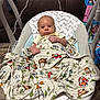 Paxton is registered to the contest to win money with this photo: baby, baby_rocker, blanket, cartoon_pattern, child, clothing, colorful, comfort, cord, couch, cute, face, flooring, head, home, indoor, infant, person, relaxation, wood_floor