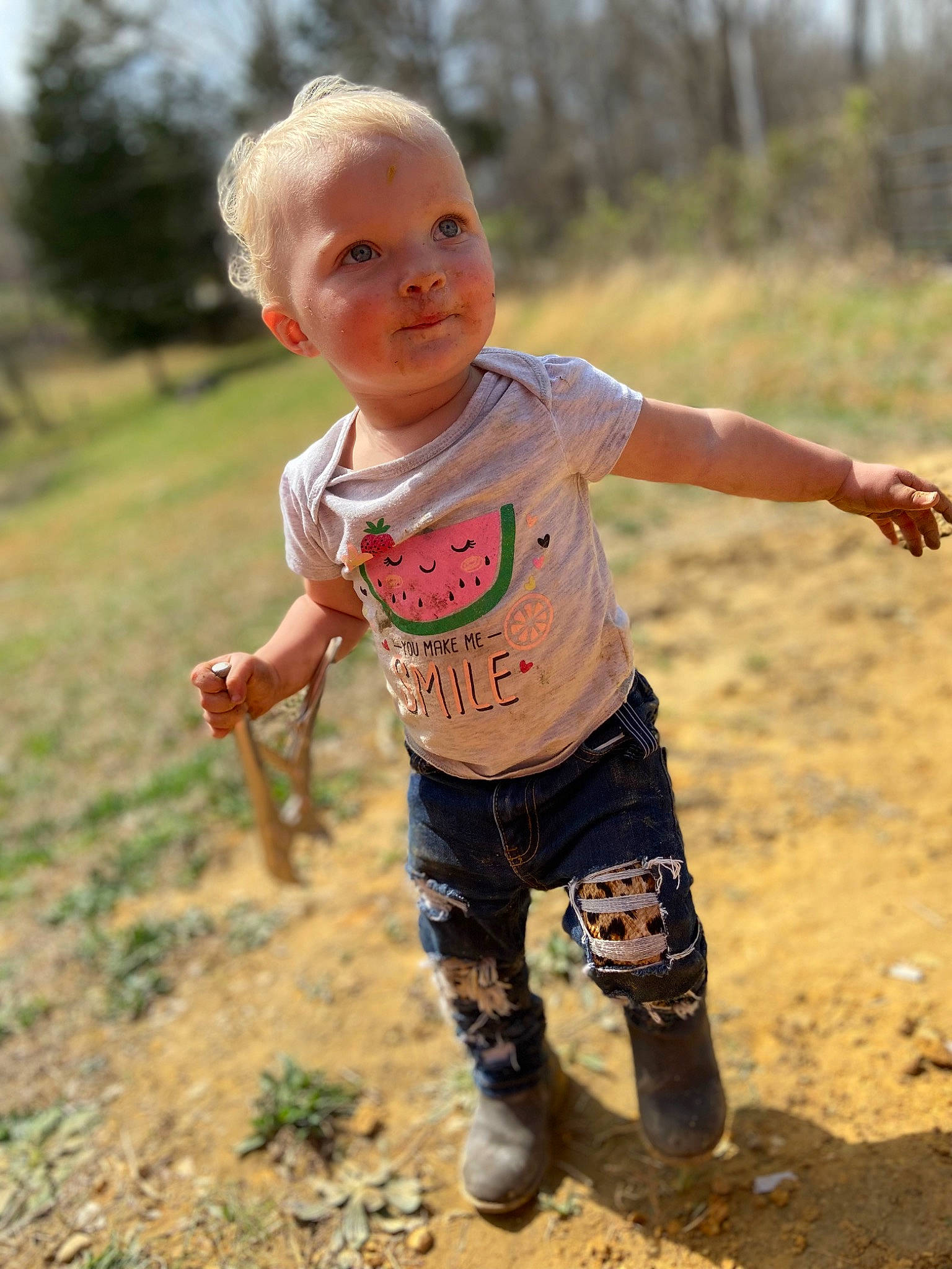 Leia is registered to the contest to win money with this photo: baby, baby_toddler_clothing, face, fun, gesture, grass, grassland, happy, head, landscape, people_in_nature, person, plant, recreation, sand, shorts, sky, soil, t_shirt, toddler