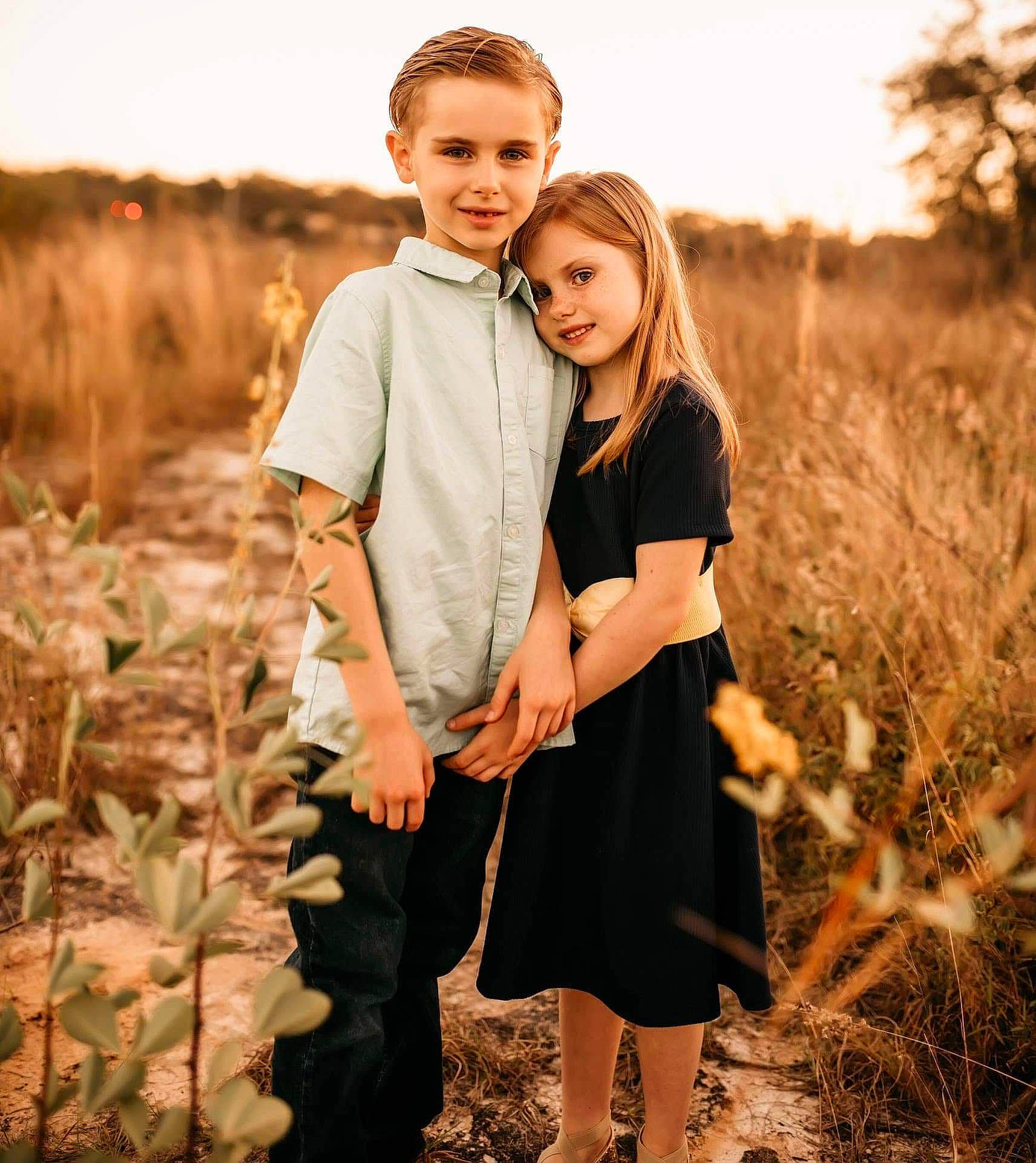 Kaiden is registered to the contest to win money with this photo: blond, facial_expression, flash_photography, formal_wear, fun, gesture, grass, grassland, hairstyle, happy, joy, landscape, long_hair, meadow, natural_landscape, people_in_nature, person, plant, standing, style
