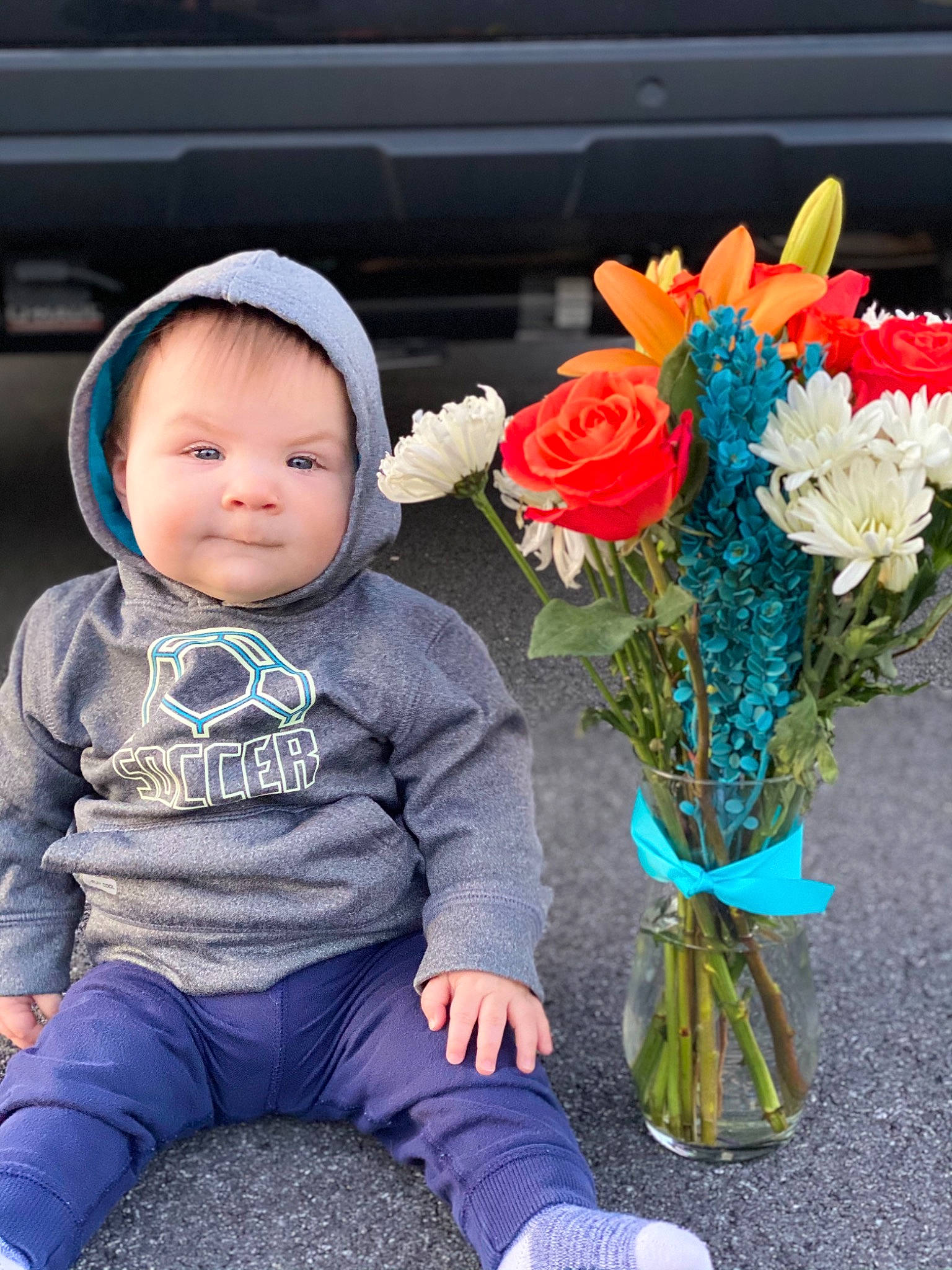 Simon is registered to the contest to win money with this photo: annual_plant, baby, baby_toddler_clothing, blue, bouquet, cut_flowers, electric_blue, floral_design, flower, flower_arranging, happy, person, petal, photograph, plant, rose, rose_family, sitting, sleeve, toddler